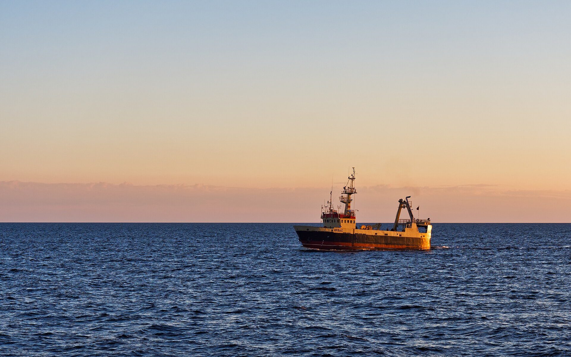 Commercial fishing vessel at sea at dawn
